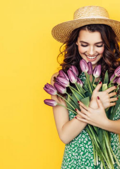 Lovely woman with purple tulips bunch